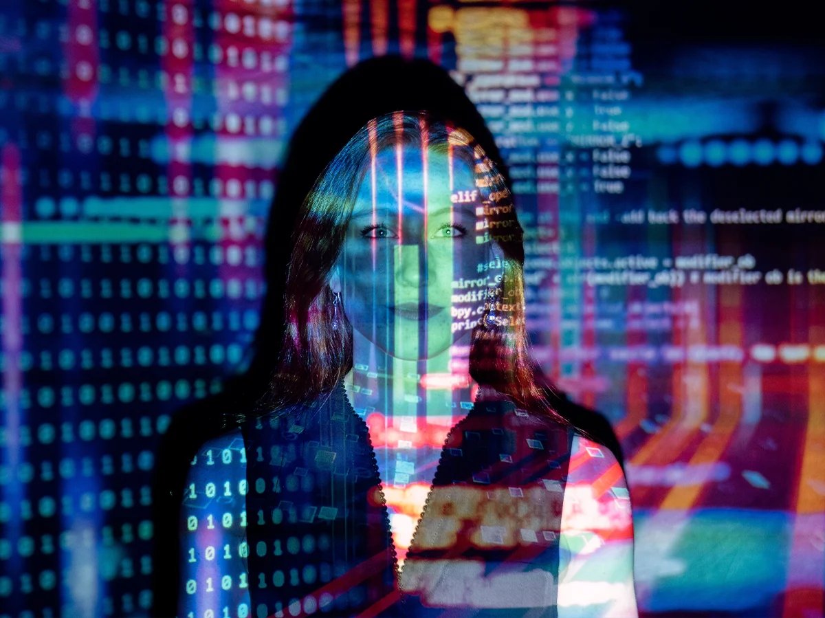 woman with colorful data projection superimposed over her face an shoulders