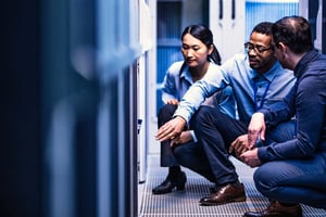 A photograph of data center operations personnel troubleshooting an issue in a data center.