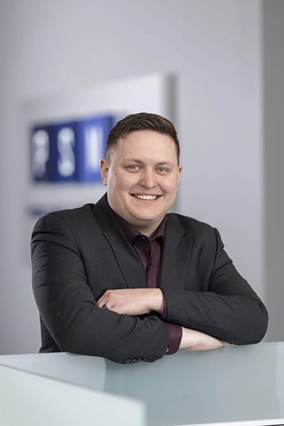 Image of Greg Schrenker, IT Sales Consultant, sitting at a desk.