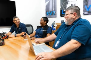 Two men and a woman sitting around a conference table