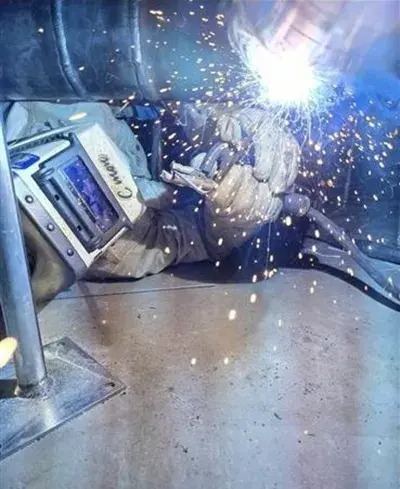 A photograph of a man welding in a data center.