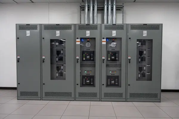 A photograph of a row of server cabinets in a data center.A photograph of power distribution units in a data center.
